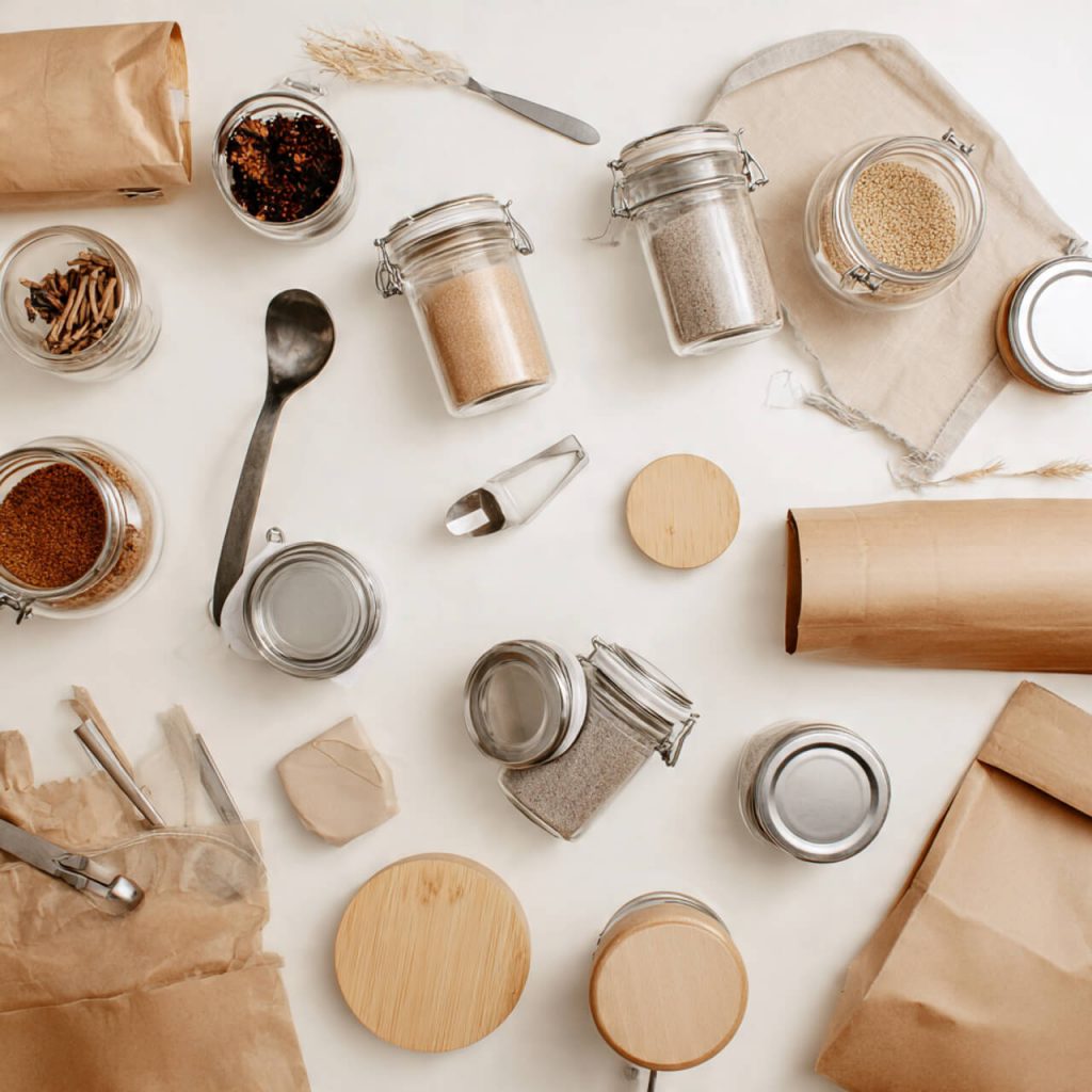 Flatlay of glass jars, dried goods, and reusable containers symbolising zero-waste refill shops